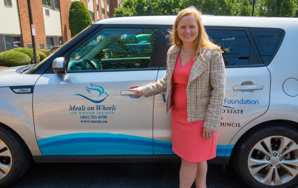 woman posng in front of meals on wheels vehicle