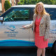 woman posng in front of meals on wheels vehicle