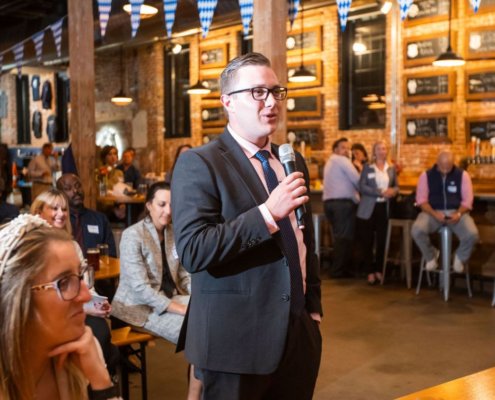 man holding micrphone and speaking in a high end bar