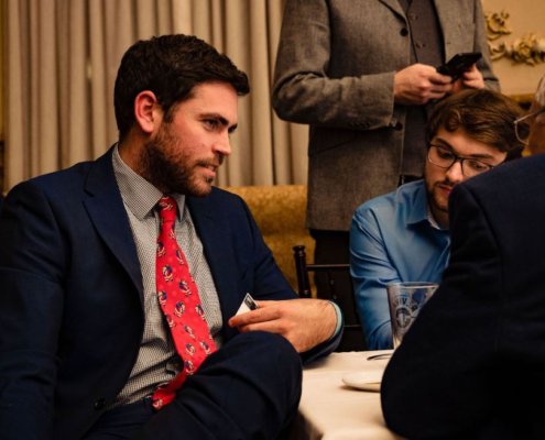 man sitting at table talking casually to others